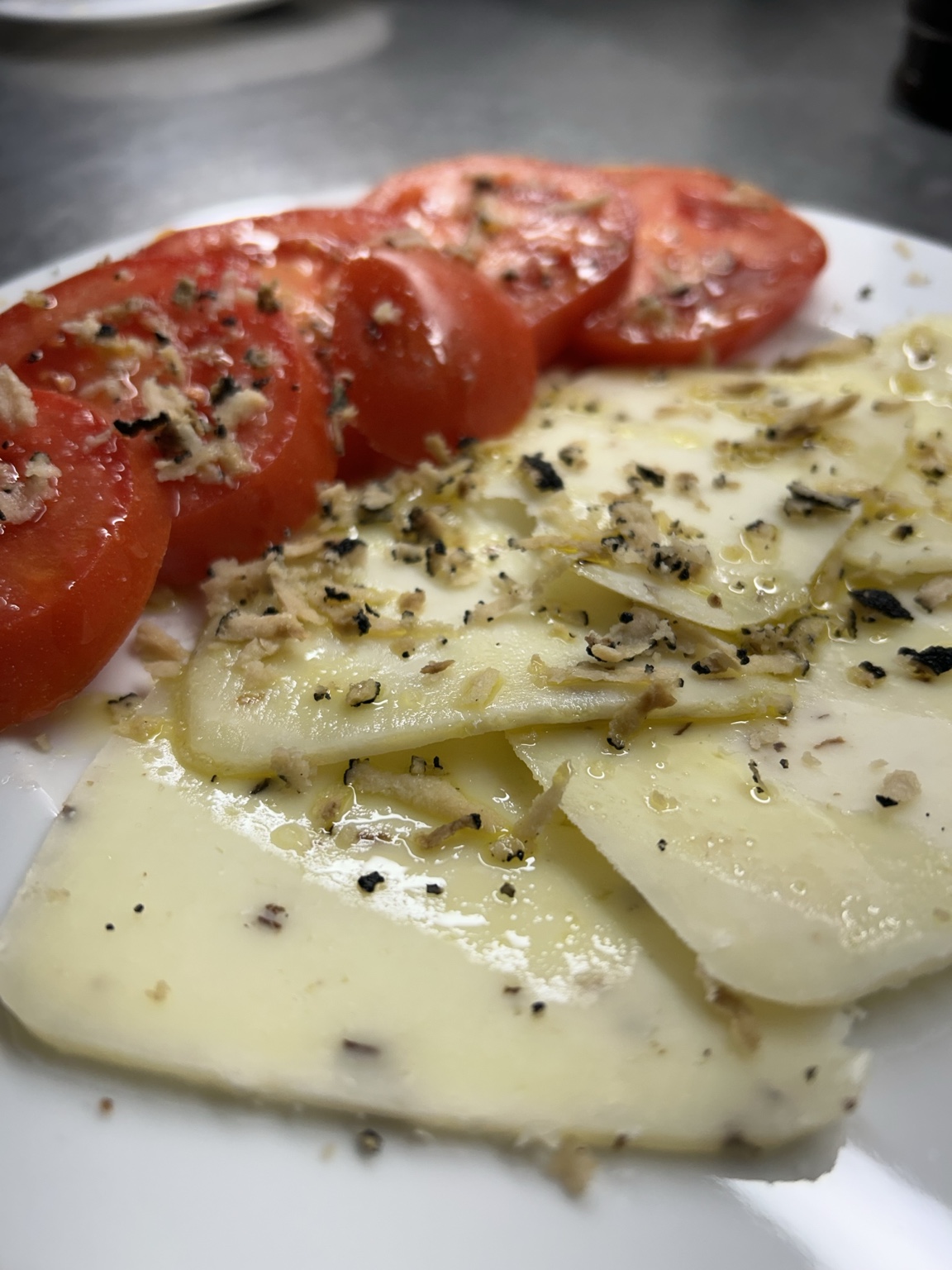 Tomate con queso de trufa, aceite de trufa y trufa rallada